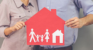Couple holding a house graphic with kids - Home Insurance